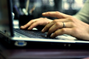 women typing on her computer to know Benefits Of Network Security Assessments