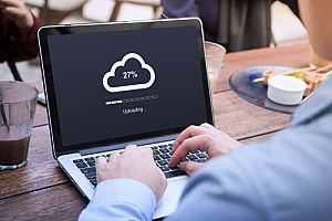 an employee uploading documents to the cloud through data backup services