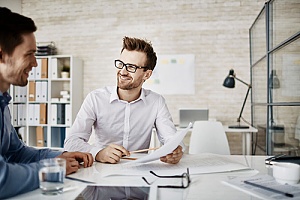 Two men having a meeting at a table to discuss nyc it help desk support