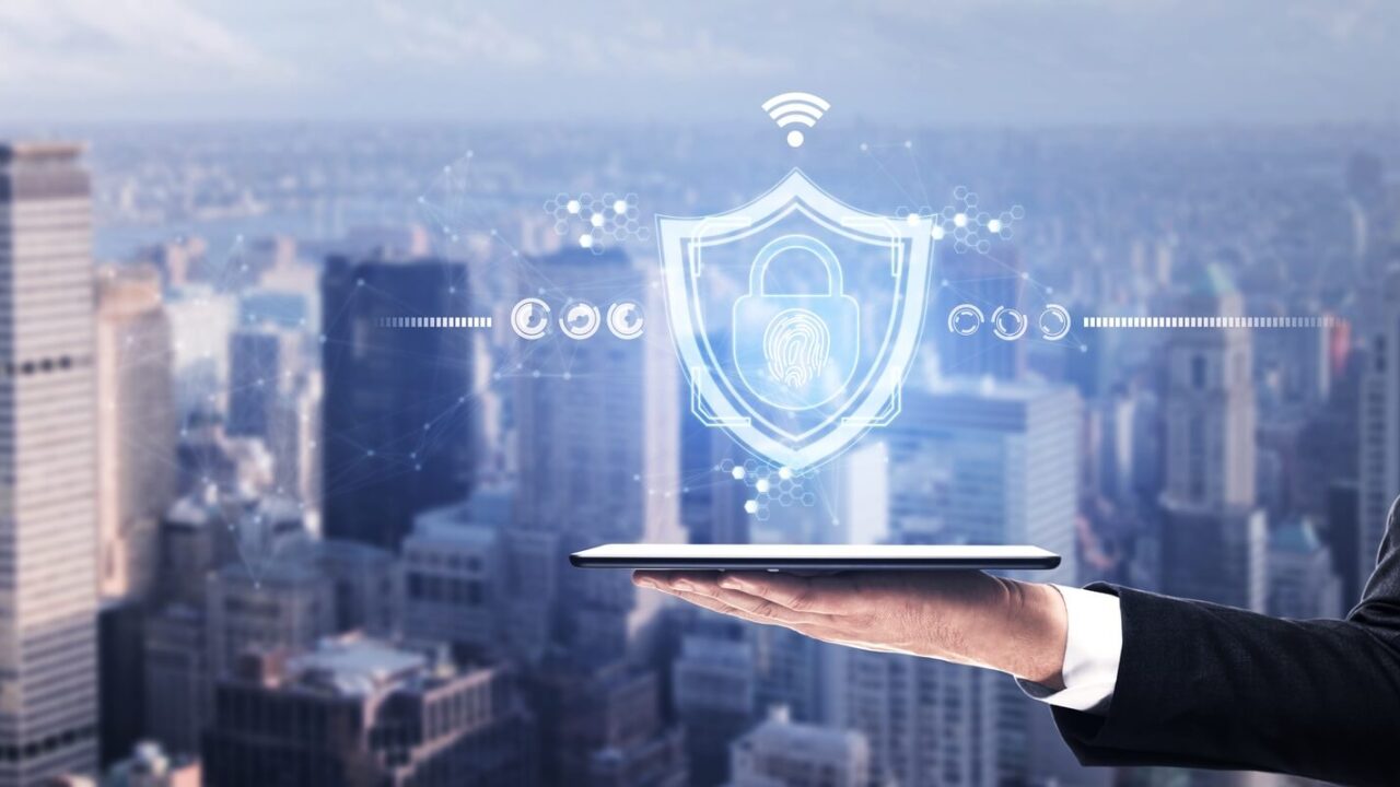close up of hand holding tablet with abstract web protection and thumbprint id safety hologram
