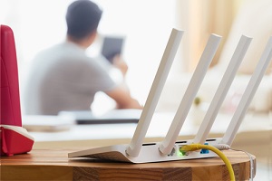 closeup of a wireless router and a man using smartphone