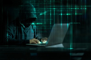 Cyber criminal typing in laptop