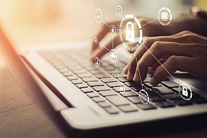 diagram of it security locks on top of a person typing on a laptop keyboard