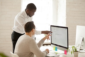 Employees pointing at a monitor in it help desk services