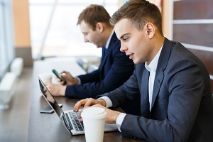 modern it experts with laptop entering business information