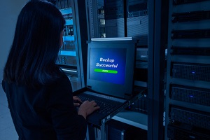 network administrator in data center room backing up data