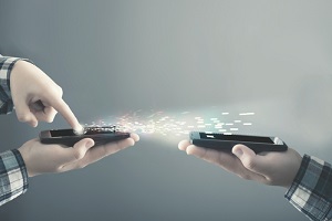 teenager transfering data from a smartphone to another one