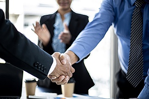 two business owners shaking hands after a successful business cabling test
