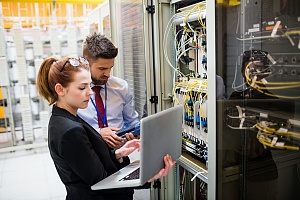 two it security workers in a large server room fixing an issue for a client