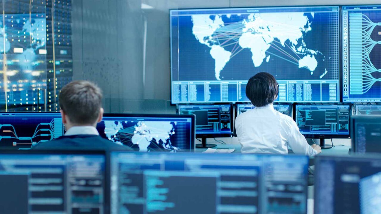 two men working inside of a cyber security office