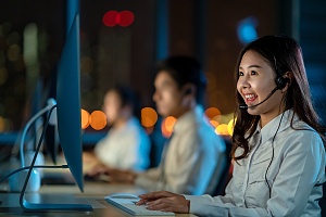 women who works in the insurance industry typing on a computer with headset