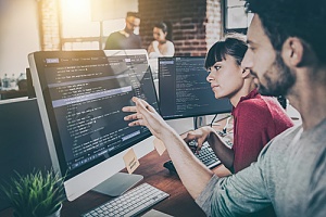 Employees working together at large computer screen providing managed service provider service to a business